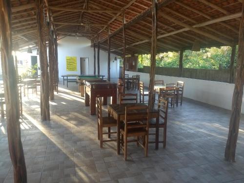 a restaurant with wooden tables and chairs in a pavilion at Porto dos Lencóis - Chalé Tipo Apartamento in Barreirinhas
