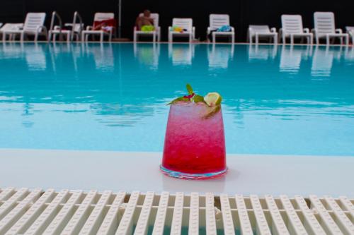 a drink sitting on a table next to a swimming pool at Villaggio Turistico Defensola in Vieste