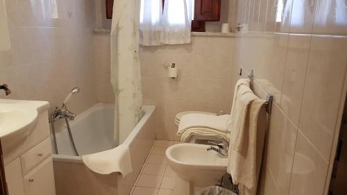 uma casa de banho com um lavatório, uma banheira e um WC. em Amelia Hotel em Momigno