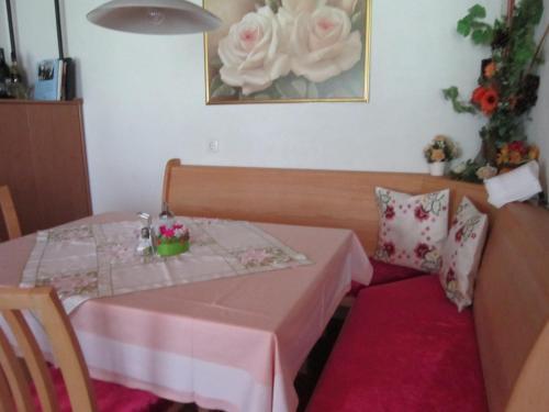 a small table with a pink table cloth and flowers on it at Haus Jochum in Langen am Arlberg