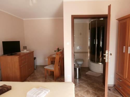 ハジコビにあるPokoje Gościnne - Noclegi Charzykowyのベッド1台、バスルーム(テレビ付)が備わる客室です。