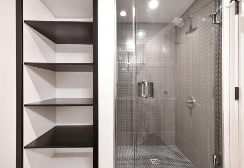 Un baño con ducha con puerta de cristal. en Global Luxury Suites in South End, en Boston