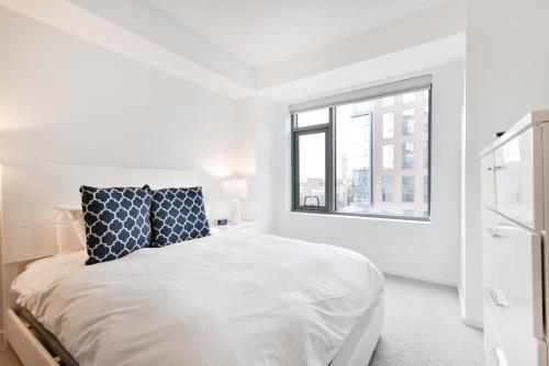 Un dormitorio blanco con una cama y una ventana. en Global Luxury Suites in South End, en Boston