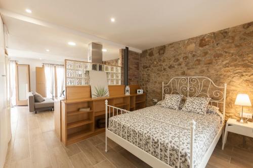 sypialnia z łóżkiem i kamienną ścianą w obiekcie Lets Holidays apartment Sant Miquel w Tossa de Mar