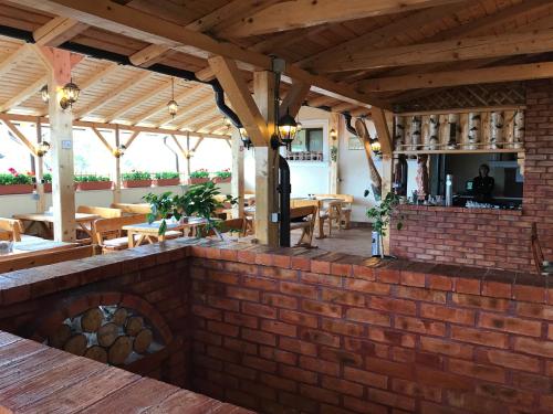 an outdoor patio with a brick wall and tables at Casa Maria Arges in Piteşti