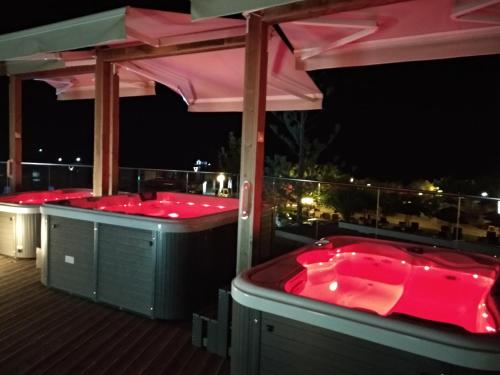 a couple of hot tubs on a deck at night at Georgioupolis Beach Hotel in Georgioupolis