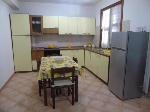 a kitchen with a table and a refrigerator at Appartamento Marconi 13 in San Vito lo Capo