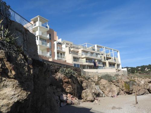 - un bâtiment sur une falaise à côté d'une plage dans l'établissement Appartement Vue Mer - Sète, à Sète