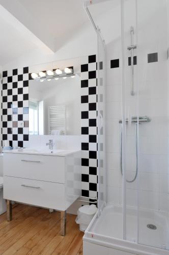 a bathroom with a white sink and a shower at Temporesidence Chateauneuf in Bayonne