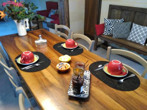 ein Holztisch mit Hüten und Tellern mit Essen darauf in der Unterkunft Les chambres d'Ausilia in Sablons