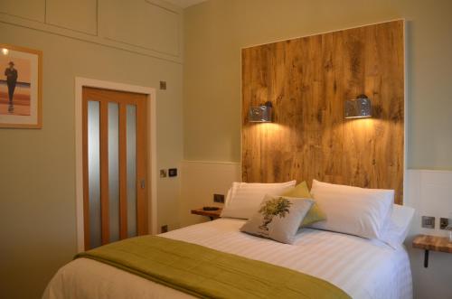 a bedroom with a bed with a wooden headboard at Rosemount Boutique B&B in Lanark