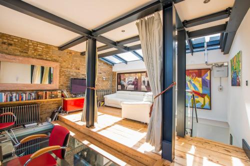 una sala de estar de planta abierta con una pared de ladrillo en Penthouse, en Londres