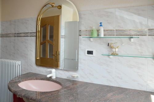 a bathroom with a pink sink and a mirror at Ferienwohnung Leachwies in Schenna