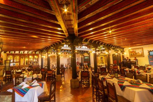 a restaurant with tables and chairs in a room at Hotel Posada de Don Rodrigo Antigua in Antigua Guatemala