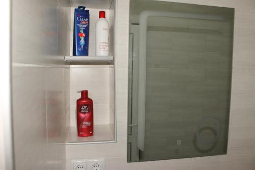 een badkamer met 2 flessen zeep en een spiegel bij Sea view apartment in Batoemi