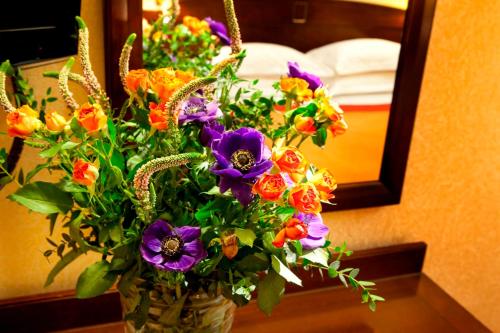 a vase filled with flowers on a table in front of a mirror at Hotel Paix Republique in Paris
