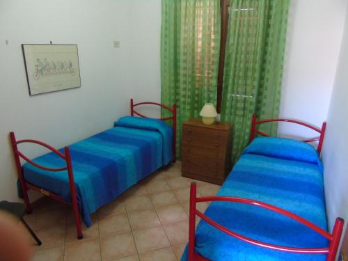 サン・ヴィート・ロ・カーポにあるAppartamento Marconi 15のベッドルーム1室(ベッド2台、ドレッサー、カーテン付)