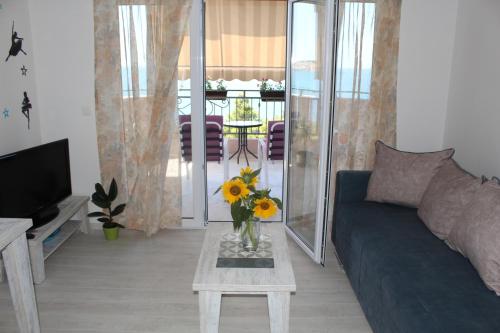 sala de estar con sofá y mesa con flores. en Vila POGLED, en Bar