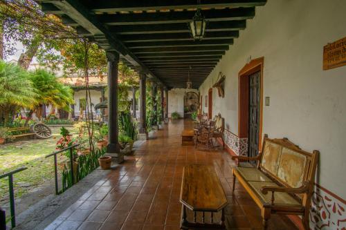 a porch of a house with a table and benches at Hotel Posada de Don Rodrigo Antigua in Antigua Guatemala