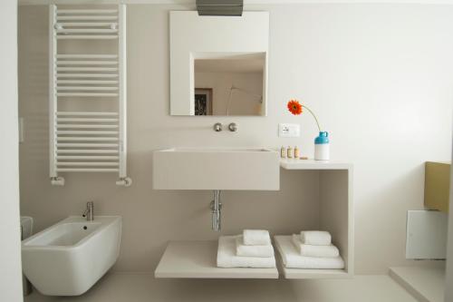 a white bathroom with a sink and a mirror at Dimora Talenti in Polignano a Mare