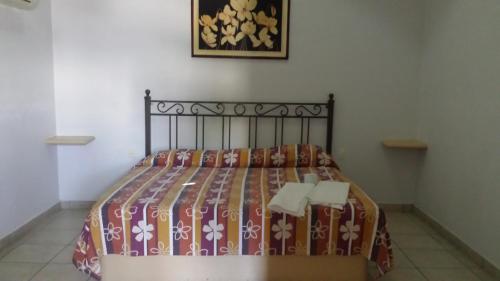 a bed in a bedroom with a bedspread on it at Hotel Posada La Pastrana in Jojutla de Juárez