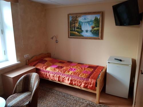 a bedroom with a bed and a painting on the wall at Nina puhkemaja in Nina