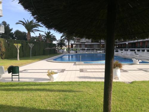 a swimming pool in a yard with an umbrella at Grandpa Beach House in Alicante