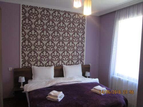 a bedroom with a bed with a black and white wall at Guesthouse Elli & Cottages in Stepantsminda