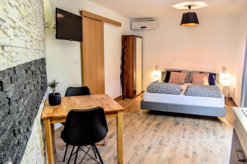 a bedroom with a bed and a table and chairs at Olive garden apartment in Molunat