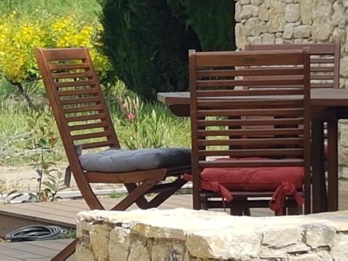 two wooden chairs sitting next to a table at Gite Les Lavandes in Vaison-la-Romaine