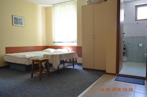 a room with a bed and a table and a shower at Guesthouse Opal in Ravda