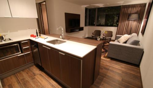 cocina con fregadero y sala de estar. en Sites Hotel, en Medellín