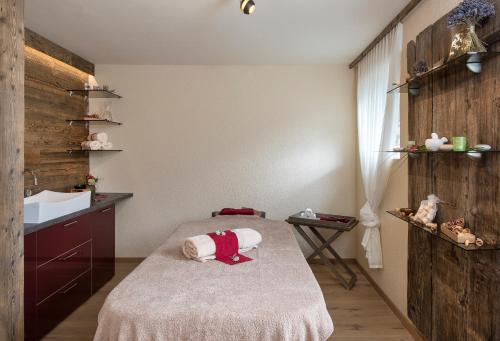 a small room with a bed and a sink at SALZANO Hotel - Spa - Restaurant in Interlaken