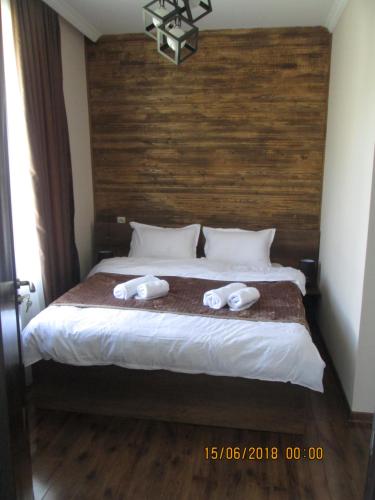 a bedroom with a bed with two towels on it at Guesthouse Elli & Cottages in Stepantsminda