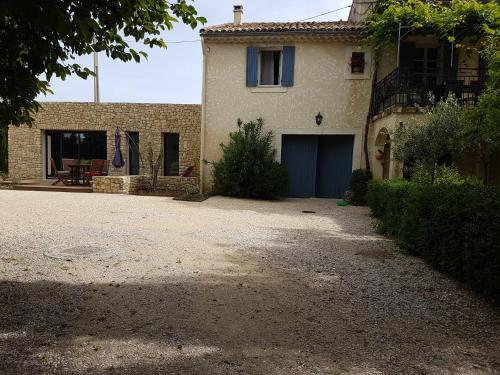 a house with a blue garage in front of it at Gite Les Lavandes in Vaison-la-Romaine