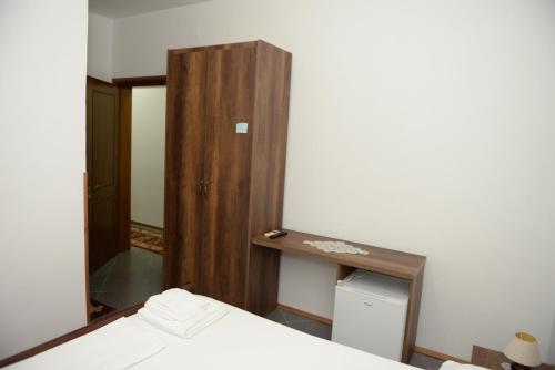 a bedroom with a bed and a mirror at Villa Juri Garden in Berat
