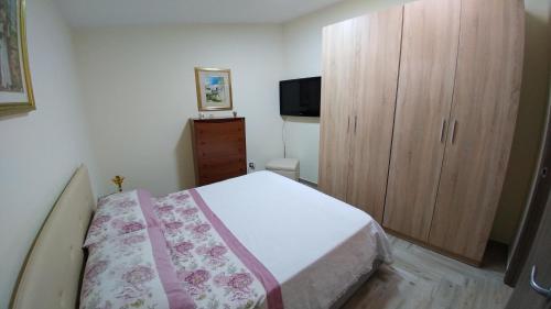 エーボリにあるLa casa del " BEATO"のベッドルーム1室(ベッド1台付)、木製キャビネットが備わります。