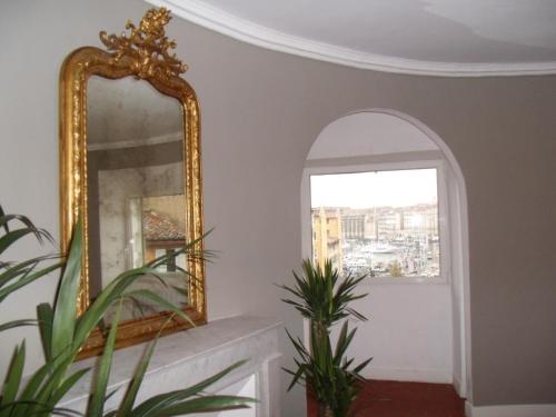 un miroir assis sur un mur à côté d'une fenêtre dans l'établissement La MAISON du PORT, à Marseille