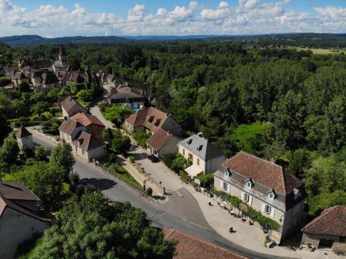 une vue aérienne sur une petite ville avec des maisons et des arbres dans l'établissement La Petite Auberge, à Carennac