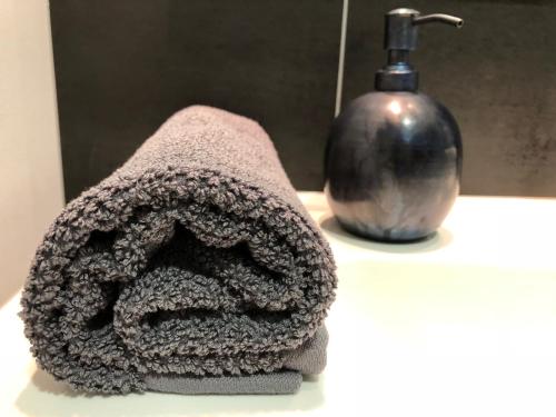 a towel sitting on a counter next to a bottle at Hotel Kolumbs in Liepāja