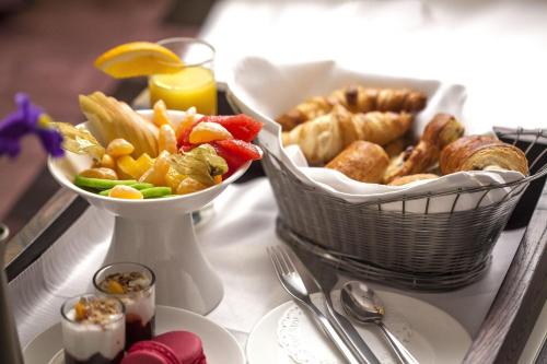 a table with a tray of food and a basket of food at Epoque Hotel - Relais & Chateaux in Bucharest