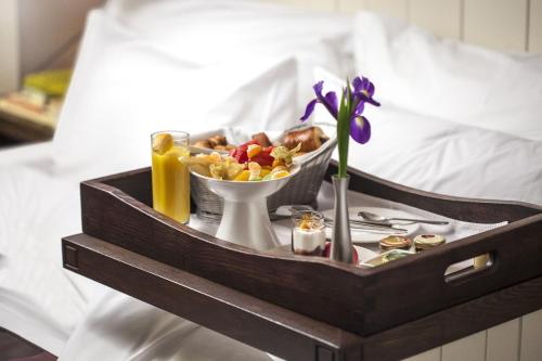 a tray of food and a bowl of food on a bed at Epoque Hotel - Relais & Chateaux in Bucharest