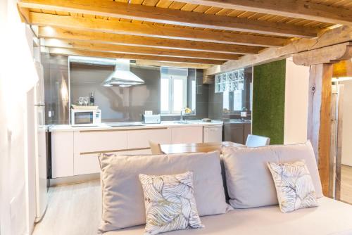 sala de estar con sofá y cocina en PINTORES ROOMS Apartamentos Turísticos, en Cáceres