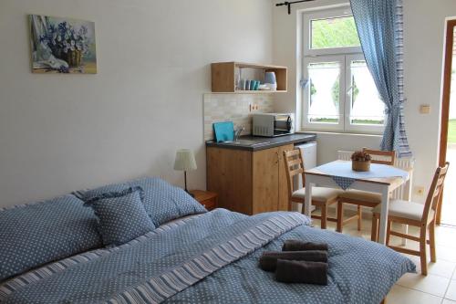 a bedroom with a bed and a kitchen with a table at Ubytovani Ve stodole in Stráž nad Nežárkou