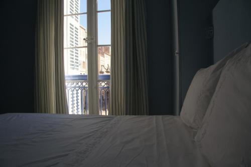 a bedroom with a bed and a large window at La MAISON de l'OPERA in Marseille