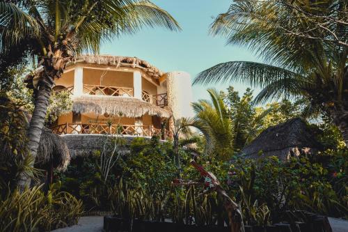 a building with palm trees in front of it at Casa Takywara in Holbox Island
