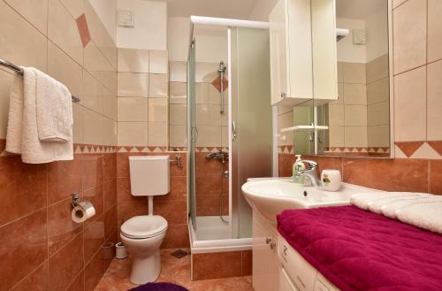 a bathroom with a toilet and a sink and a shower at Apartment Markus in Makarska