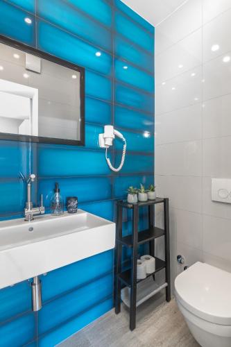 a bathroom with blue walls and a sink and a toilet at 4 Elements Old Town Views Rooms in Trogir