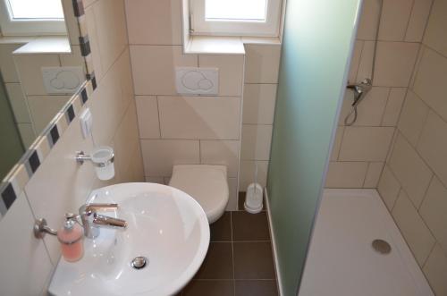a bathroom with a sink and a toilet and a shower at Apartments Buljan in Baška