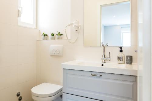 a white bathroom with a sink and a toilet at 4 Elements Old Town Views Rooms in Trogir